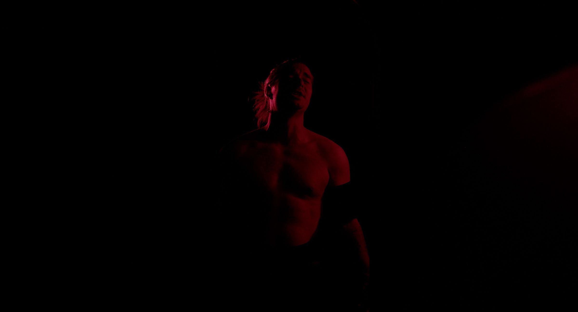 Jay Putty in dramatic red stage lighting, a still from the Worship video